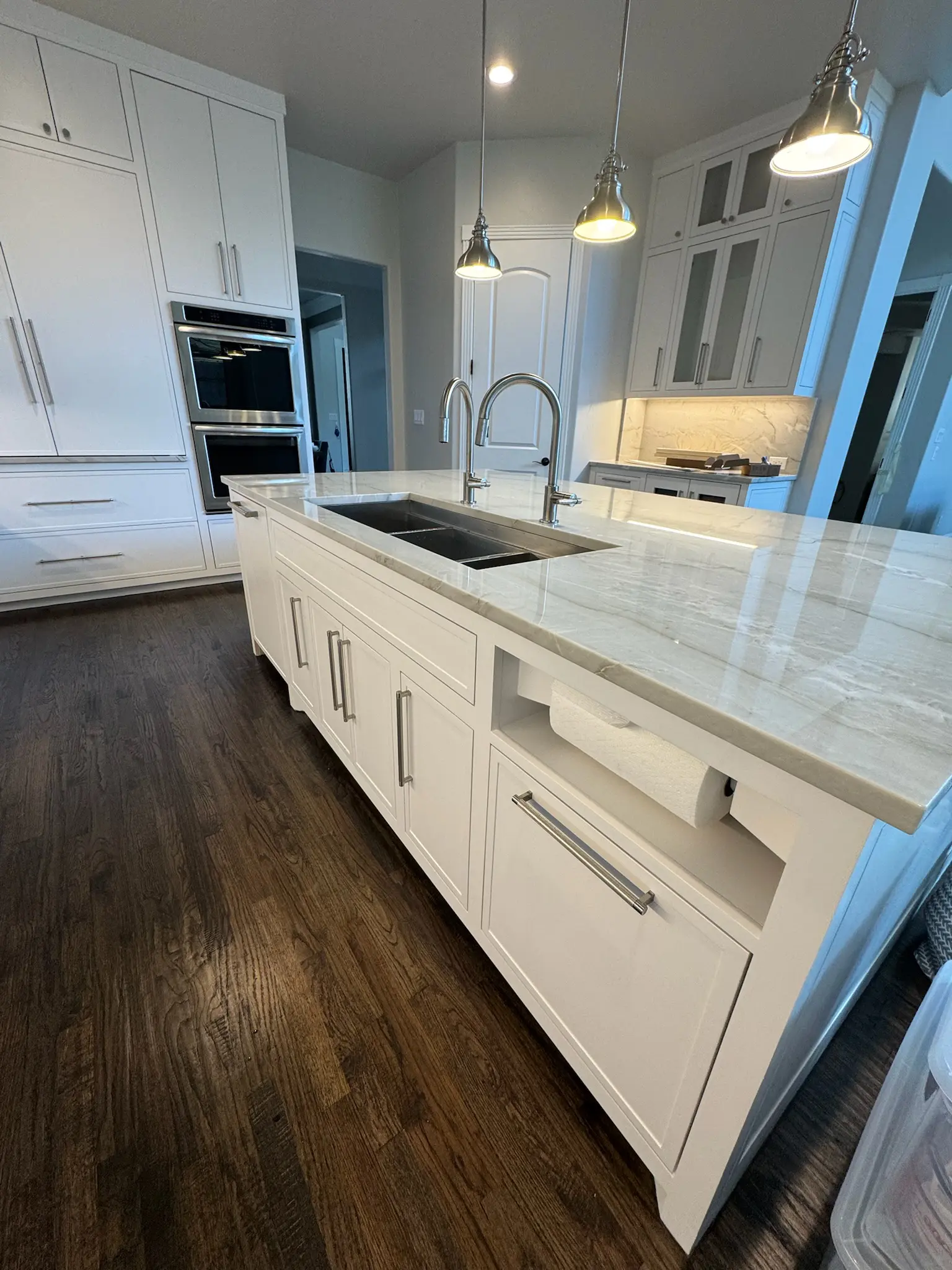 Luxury kitchen remodeling Allen, TX featuring a custom island with marble countertops, dual sinks, pendant lighting, and modern cabinetry