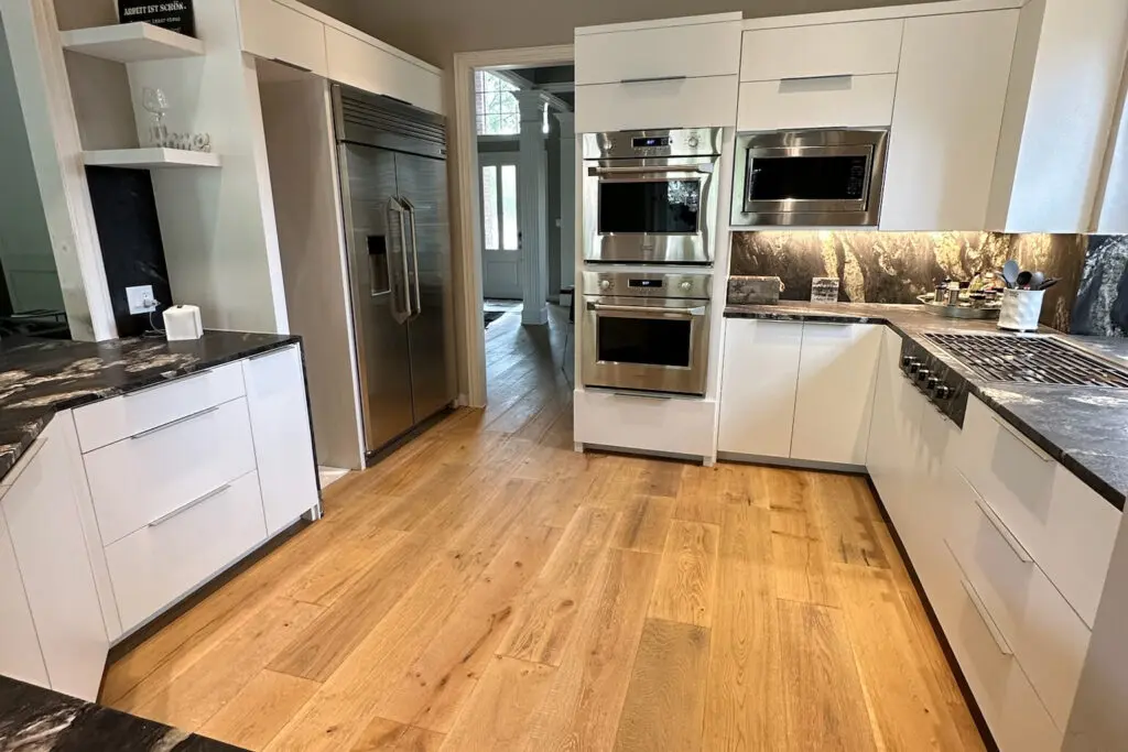 Modern white kitchen renovation showcasing granite countertops and custom cabinetry, representing typical Kitchen Remodel Cost in Plano TX