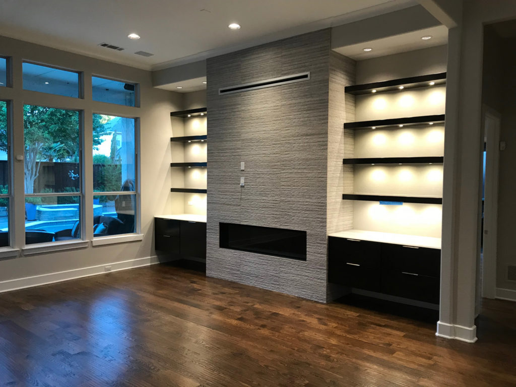 Tailored wooden shelving unit with closed‑door cabinets below in a remodeled home.