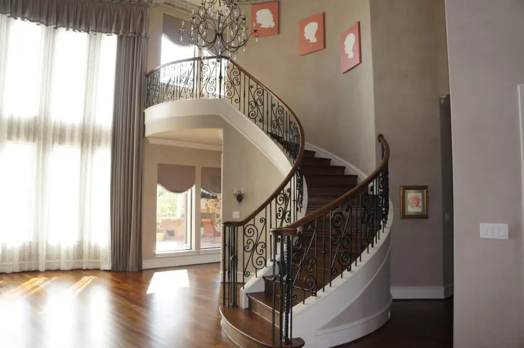 Wooden circular staircase with metal railing in a home interior remodel