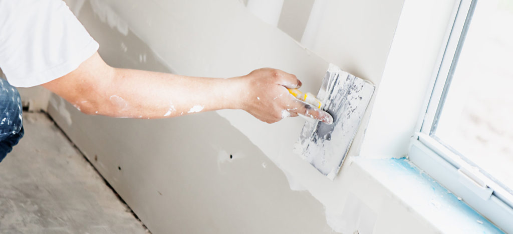 Worker doing drywall repair in plano, frisco, dallas.