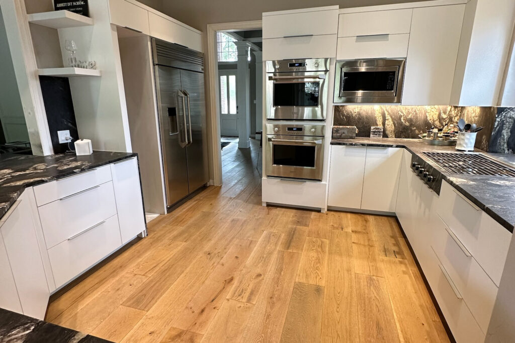 Modern white kitchen renovation showcasing granite countertops and custom cabinetry, representing typical Kitchen Remodel Cost in Plano TX