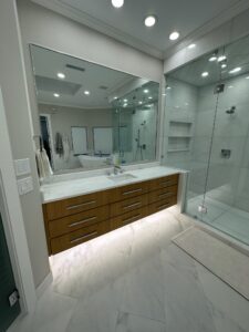 Modern luxury bathroom with floating vanity, marble countertops, and glass shower enclosure showcasing bathroom remodel cost in Plano