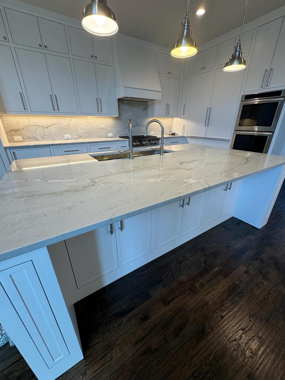 Luxury kitchen remodeling Plano, TX featuring a large quartz island countertop, white custom cabinets, stainless-steel appliances, and premium finishes. Perfect for homeowners in Plano, Frisco, Allen, and nearby North Dallas areas looking for high-end kitchen renovation.