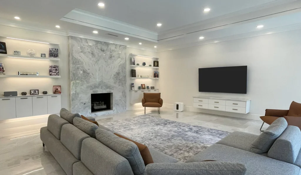 Beautiful Plano home renovation featuring a sleek modern living room with marble fireplace, built-in shelving, recessed lighting, and open layout showcasing full home remodeling excellence by local experts.