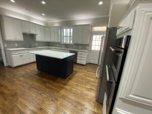 Luxury kitchen remodeling Plano & Far North Dallas featuring custom white cabinetry, hardwood floors, and a modern center island - Home Platinum Services.